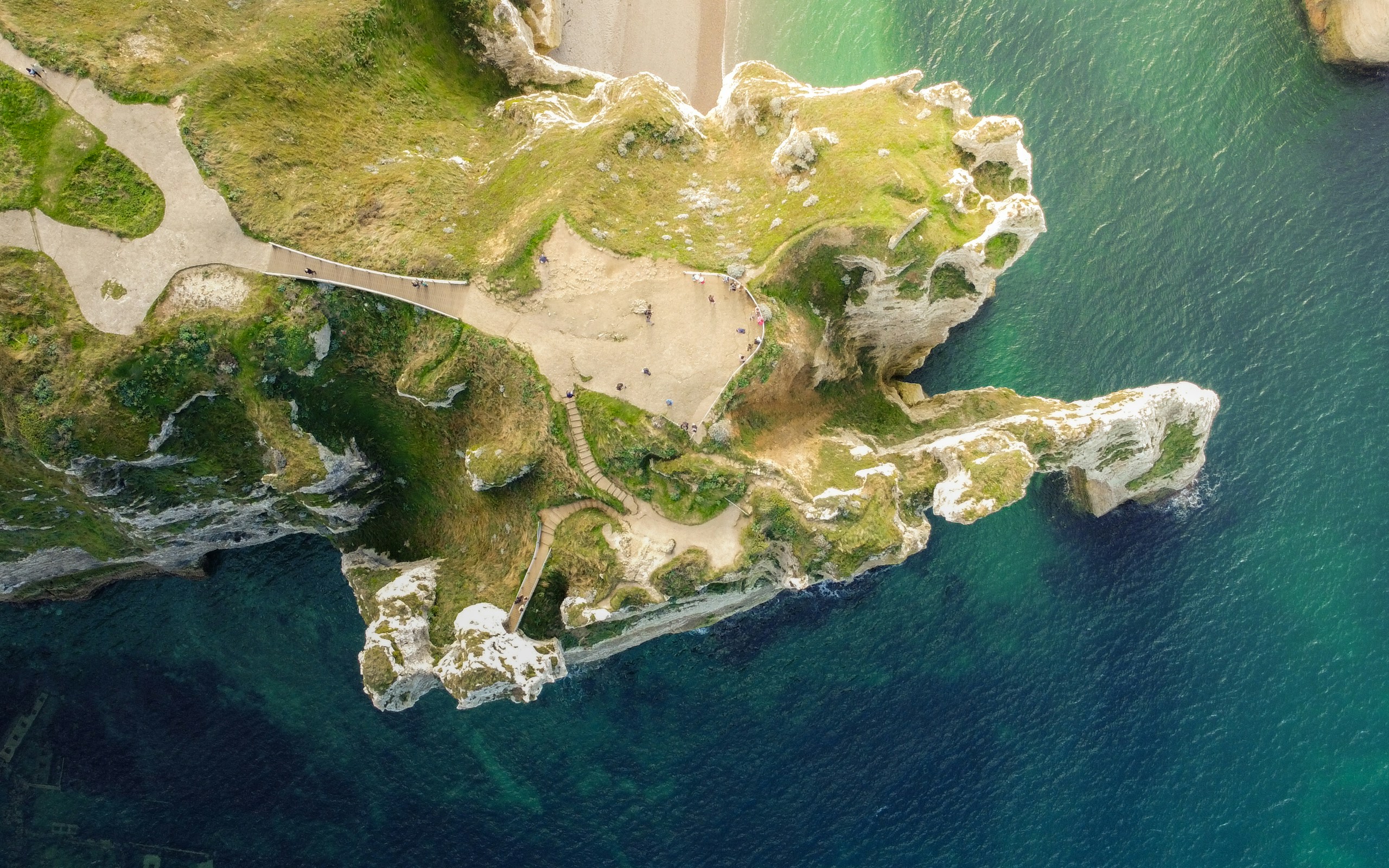 A winding path above turquoise coastal water